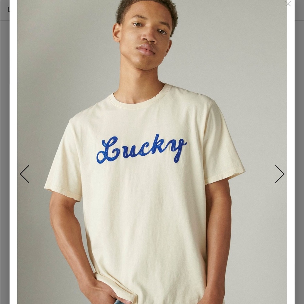 LUCKY AMAZING T WITH EMBROIDERED NAVY SCRIPT WRITING ON CREAM. DISTRESSE…